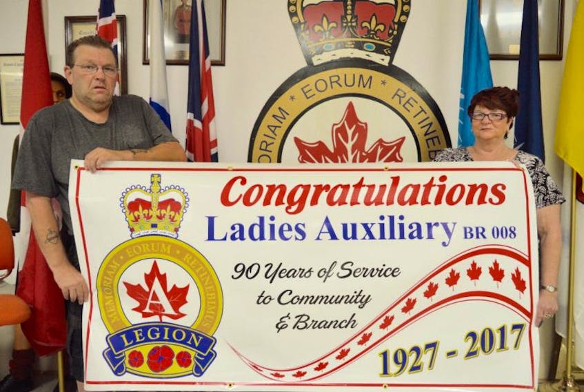 The Royal Canadian Legion branch 8 ladies auxiliary will celebrate its 90th anniversary this month. Auxiliary president Wendy Fraser, right, and branch president Brian Bobbitt are pictured holding a banner honouring the milestone.
