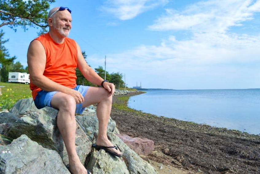 Rick Hanes relaxes on rocks by the River Ryan Campground at Lingan Bay. Hanes, who credits the New Waterford ‘water fence’ to learning how to swim, has been enjoying the two-mile swim across Lingan Bay for 50 years.