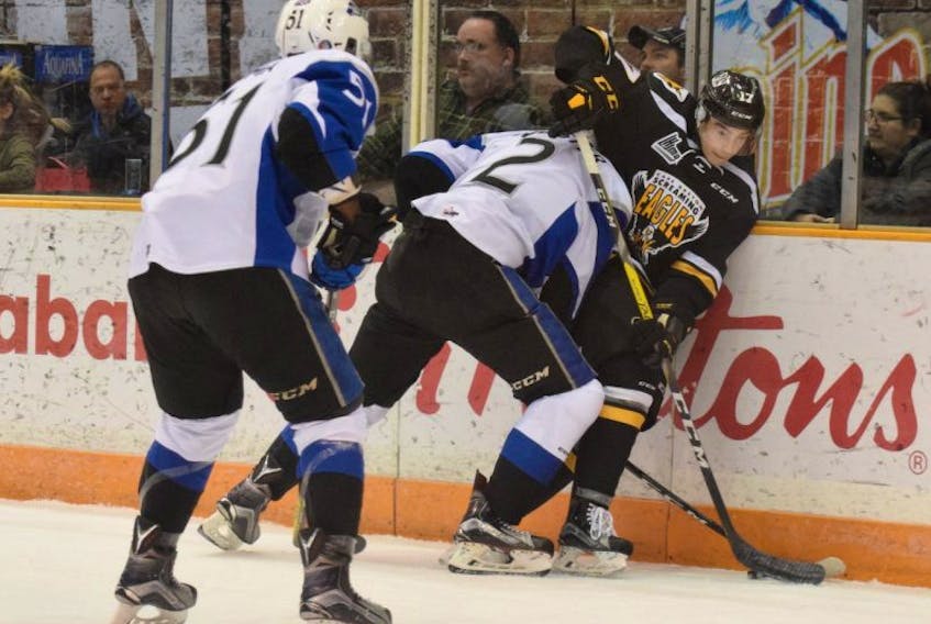 Saint John Sea Dogs defenceman Bailey Webster (2) contains Cape Breton Screaming Eagles forward Olivier Bourret along the boards during Wednesday’s Quebec Major Junior Hockey League game at Harbour Station in Saint John, N.B. Shown in the foreground looking for a loose puck is Sea Dogs left winger Bokondji Imama.