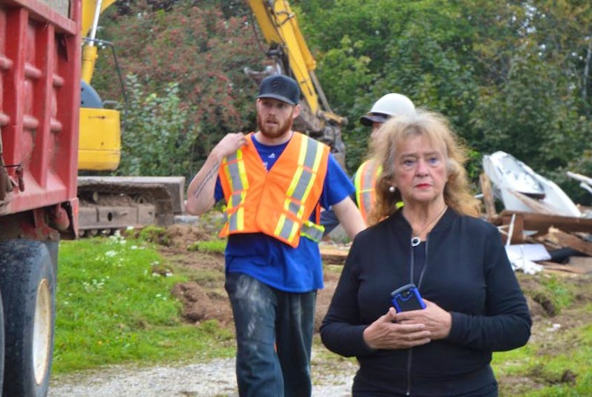 Sylvia Dolomont, middle, stands with her lawyer, Nicholas Burke, not shown, as crews work to clear debris caused by the demolition of Dolomont’s home on Campbell Street in North Sydney. The Cape Breton Regional Municipality tore down the home on Wednesday evening after Dolomont’s lengthy battle to save it.