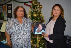 Heidi Marshall, senior consultant with the Nova Scotia Native Women’s Association, left, and association president Cheryl Maloney pose with a photo of Jane Paul that hangs in the Mi'kmaq Women’s Resource Centre in Sydney, which was renamed Monday in memory of Paul. Paul was a strong supporter of the centre from its opening a year ago until her death in March.