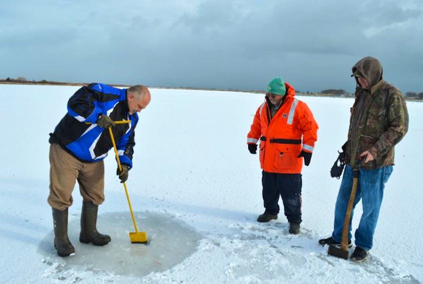 Rob Boutilier, left, president of the Port Morien Wildlife Association, demonstrates the proper way to check ice thickness accompanied by members Stan Peach, centre, and Jeff McNeil.