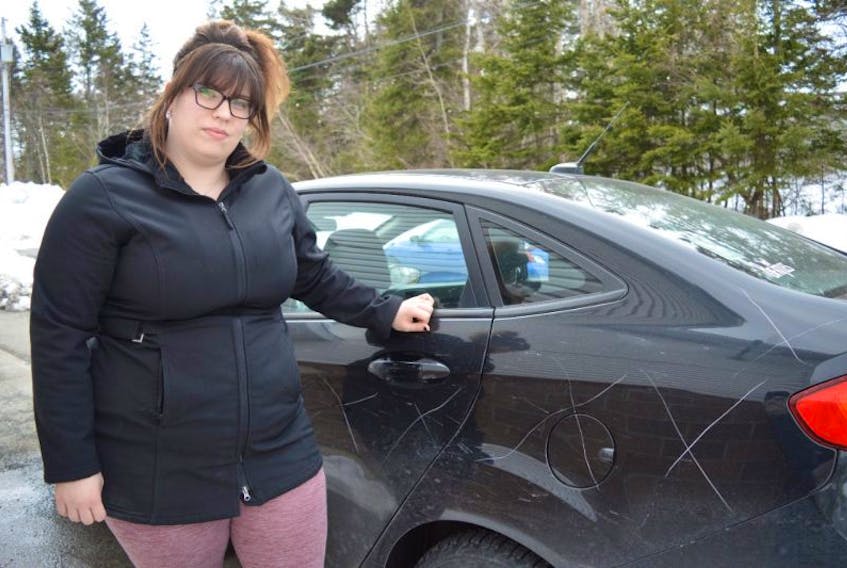 Haley Johnston is pictured by her 2013 Ford Fiesta that was vandalized sometime between 12:15 a.m. and 3:30 p.m. on Tuesday on Alexandra Street in Sydney. Johnston is still wondering why she was targeted.