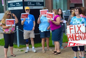 Dozens of people stand in front of the federal government building on Dorchester Street on Wednesday to protest the Phoenix Pay System.