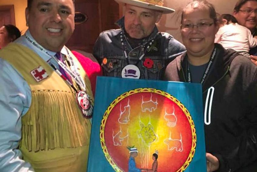 Regional Chief Morley Googoo, left, and Loretta Gould, right, of Waycobah present Gord Downie, middle, with a special painting, entitled “Share our Teachings,” at the Assembly of First Nations on Tuesday in Gatineau, Que. The painting was created by Gould for Downie.