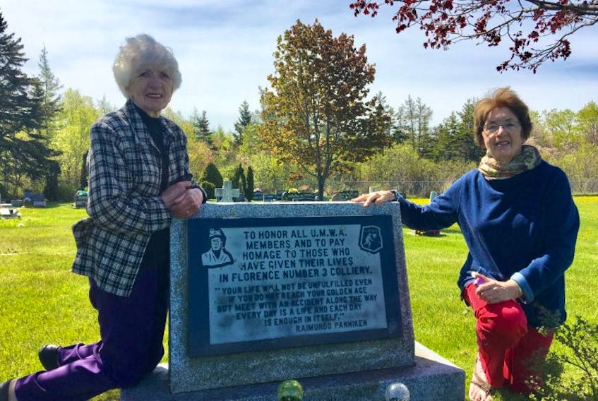 Evelyn MacDougall, left, and Eileen Romeo kneel beside a monument that honours miners who lost their lives and those who worked in No. 3 Colliery in Florence. The sisters have been arranging a William Davis Miners’ Memorial Day cemetery service each year since 1999 to honour all miners from their surrounding community.