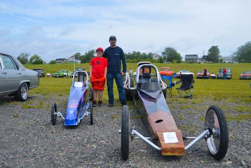 From left, 10-year-old Gavin Pozzebon and his father, Chris Pozzebon, stand beside their dragsters which they race locally and at different tracks around the Maritimes.