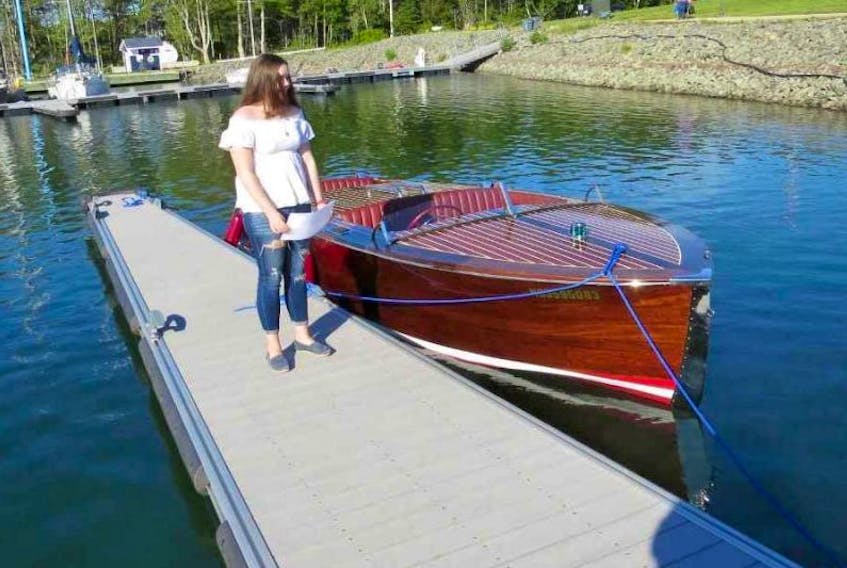 Kaileigh Rowe, granddaughter of Don Rowe, christens his boat Rowe’s Wood at the Ben Eoin Marina in June. Rowe, a retired harbour master, spent more than two years building the vintage mahogany-hulled runabout in his backyard garage before finally launching it this summer.