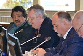 CBRM councillors Esmond Marshall, left, and Deputy Mayor Eldon MacDonald, at right, listen Tuesday as Steve Gillespie reads his motion to eliminate the $140 weekly allowance that members of council can currently claim.