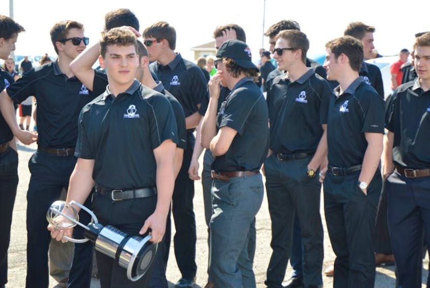 Members of the Cape Breton West Islanders, including captain Jacob Hudson holding the Telus Cup, gather before entering the Al MacInnis Sports Centre in Port Hood on Sunday. About 500 people attended a community celebration honouring the team’s historic season.
