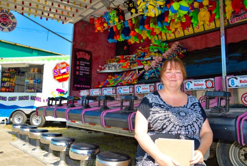 Pauline MacLeod, facilities manager of the Cape Breton Exhibition, is shown in front of a carnival game as preparation continued Thursday for this year’s Cape Breton County Farmers Exhibition. The weeklong exhibition begins on Monday in North Sydney.