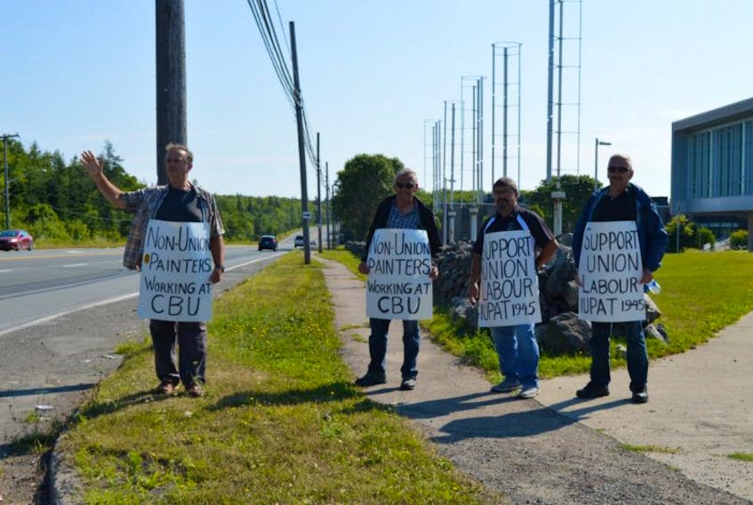From left, Gary Boudreau waves at a car honking in support of the unionized painters protesting outside Cape Breton University this week. Beside him are Kevin Penney, Gerald Phillippo and Gerald Boudreau. The painters, members of International Union of Painters and Allied Trades local 1945, staged an information picket to protest the use of a non-union contractor.