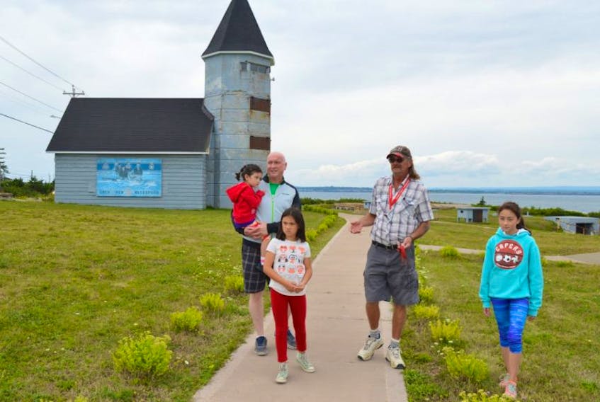Rob Grezel, co-ordinator of Fort Petrie Military Museum and volunteer with the Sydney Harbour Fortification Society, shows from left, Lorne MacKinnon of Toronto and his daughters Scotia, 4, Stirling, 8, and Skye, 11, around the fort in New Victoria.