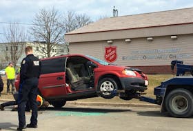 Police and onlookers watch as a van is towed away from Inglis Street at about 12:30 p.m. on Wednesday, April 12, 2017.