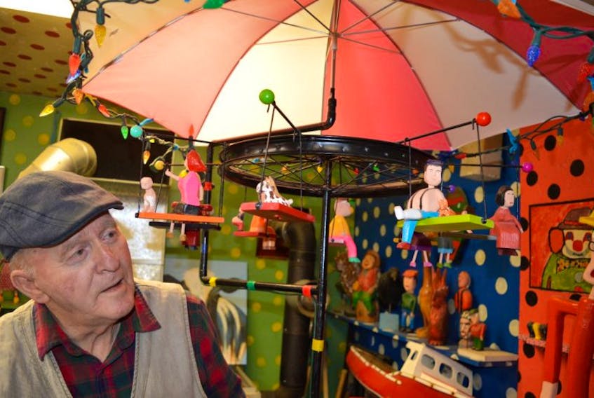 Murray Gallant, 78, of New Waterford shows the unique carousel he carved which will be accepted by the Art Gallery of Nova Scotia in Halifax next week. This will result in Gallant now having a total of 16 pieces of his art on display at the museum. Gallant said he not only loves to carve but enjoys putting humour in his pieces, shown by everything from a pig licking an ice-cream cone, to man in a cast sitting with his cat on the carousel.