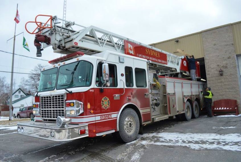 The North Sydney Volunteer Fire Department will take delivery of the ladder truck pictured above, as soon as Sydney’s new replacement arrives. Deputy Chief Wade Gouthro (on the truck) and Wayne Currie of Rock-Dale Overhead Doors take measurements to determine the work required at the fire station to accommodate the ladder truck.