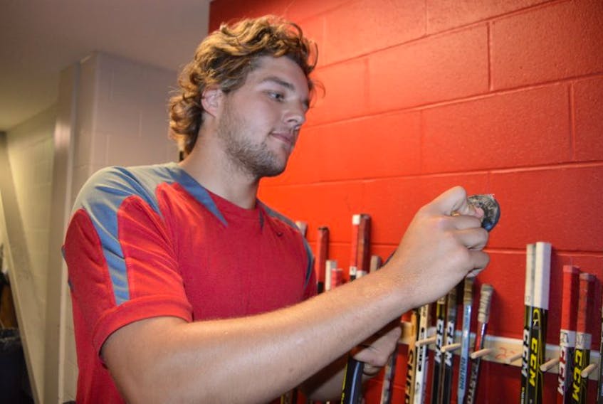 Defenceman Chris Osmond of the Kameron Junior Miners puts wax on his stick blade prior to team practice Wednesday at the Membertou Sport and Wellness Centre. The Junior Miners open the season Saturday at home when they host the Strait Pirates.