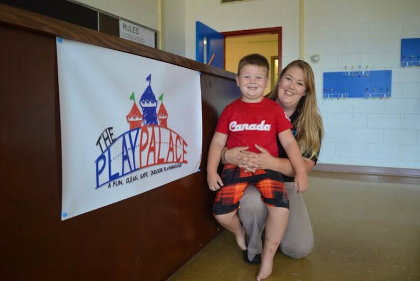 Five-year-old Case Barrington, chief toy tester at The Play Palace, sits on his mom Rebecca’s lap. She is the owner of a new indoor play facility in Sydney and expects to be open by the first week of October.