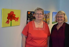 Beth Fillmore-Chisholm is shown with artist Catherine Moir in front of a series of paintings that Fillmore-Chisholm did for the upcoming Art of Living exhibit at the Cape Breton Centre for Craft and Design’s Loft Gallery in downtown Sydney. The painting of an amaryllis depicts the various stages of life.