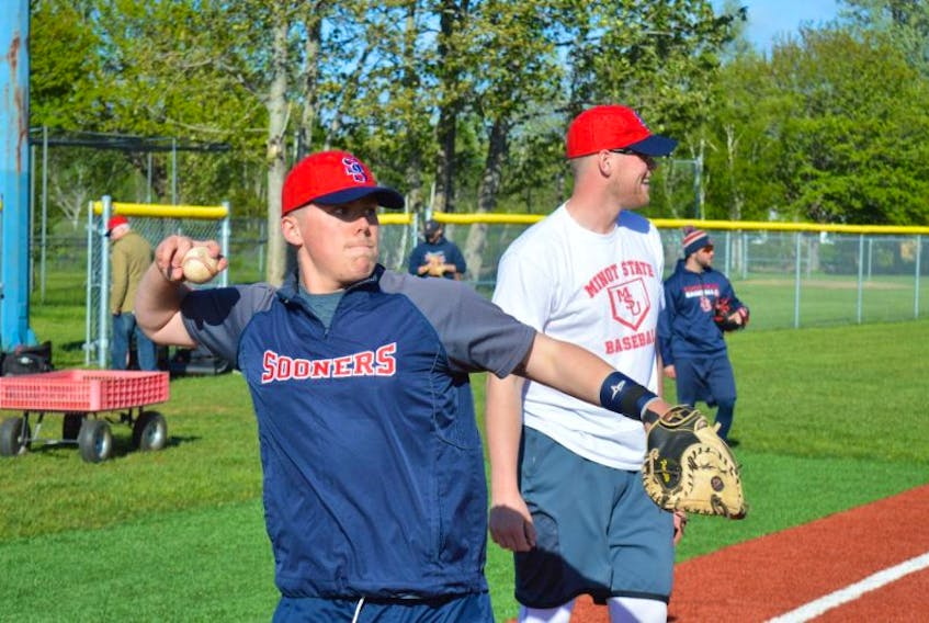 From left, Sean Ferguson and Reilly O’Rourke of the Sydney Sooners warmup prior to team practice at Susan McEachern Memorial Ball Park in Sydney on Wednesday. The team was preparing for its home opening weekend against the Truro Bearcats.