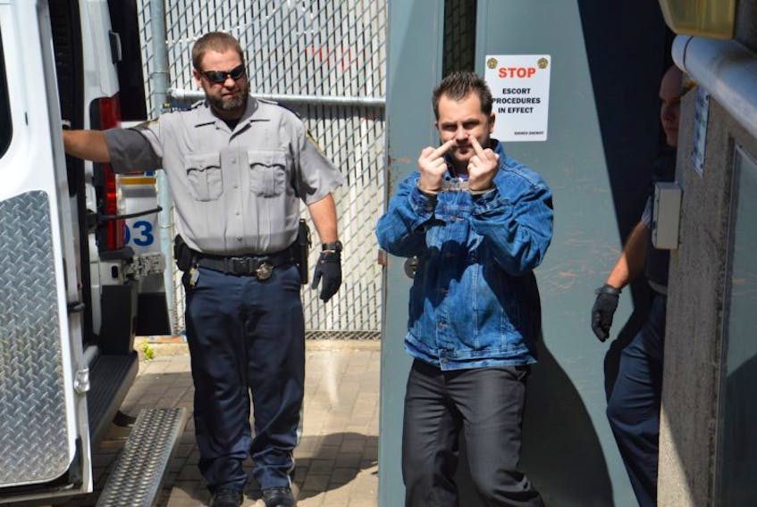 Convicted murderer Brandon James Berthiaume, 26, of Ben Eoin, gives a news photographer a one-finger salute Monday as he was led from the Sydney Justice Centre. Berthiaume will now serve a life sentence after pleading guilty to the second-degree murder of Brandon Kelly, 25, in June 2015. A hearing later this month will determine how much time he will serve before he can begin applying for parole.