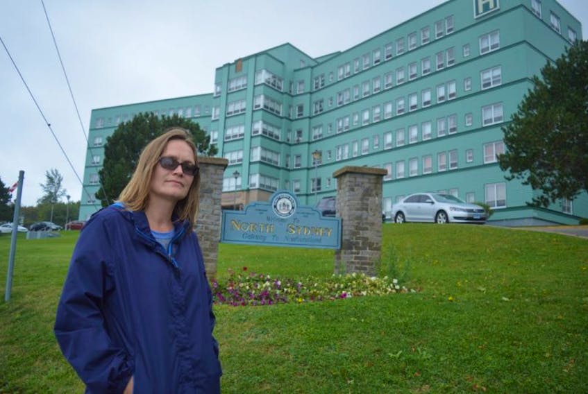 Lisa Bond stands in front of the Northside General Hospital in North Sydney on Tuesday. Bond has organized a peaceful protest for Sunday in front of the local hospital to show concern for emergency department closures and the doctor shortage in Cape Breton.