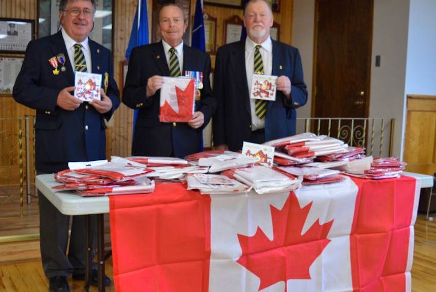 Cecil Snow, Gary Collins and Daniel Ginter of Branch 83 Royal Canadian Legion in Florence, display some of the flags that will be provided to every home in Florence to celebrate Canada’s 150th.