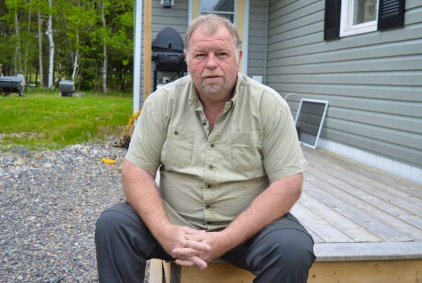 Lawrence Provost, 49, sits on the porch of his home in New Waterford. Provost was injured while working in Nunavut in December 2015 and said all the agencies in place to help Canadians in times of need have failed him. He said he has lived without any income since June 2016 and if not for help from a friend would have already lost his home.