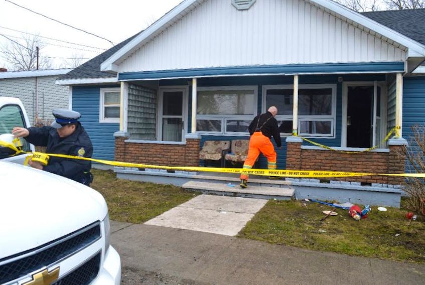 Const. Jian Ming Hu of the Cape Breton Regional Police Service puts police tape up on Monday to block off a larger section at a duplex at 43 Concord St. in Glace Bay while members of the CBRPS Ident unit, including Sgt. Mike O’Rourke, right, and the fire marshal’s office investigate a fire which claimed the life of Gerry Somerton. There was heavy traffic on the street all day Monday as people stopped to shared their stories about the deceased man.