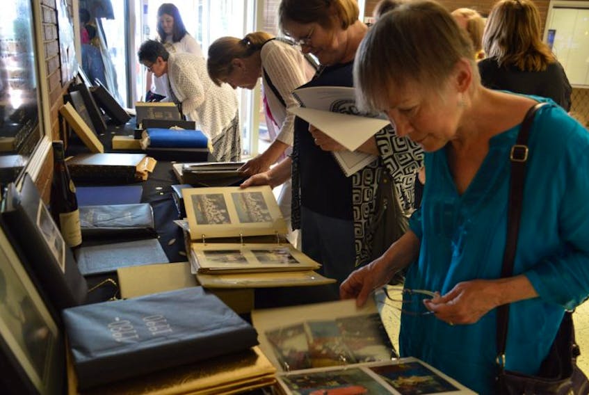 People look through the display of mementos, newspaper clipping and pictures, collected over the 50 years.