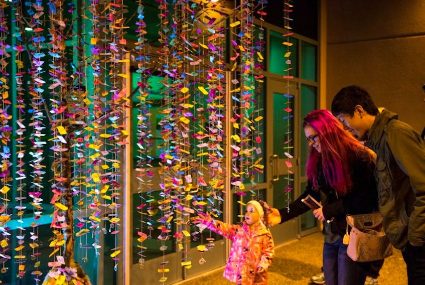 Audience members are shown with Money Tree by artist Robyn Neal at the Lumière Arts Festival in 2016.