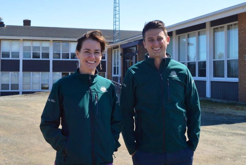 Parks Canada employees Maria O’Hearn and Coady Slaunwhite stand in front of the old administration building that has served the Cape Breton field unit since the early 1960s. The government agency is looking to move some of its workers from its present compound, located in a woodland area outside of Louisbourg, to a more central location on Main Street.