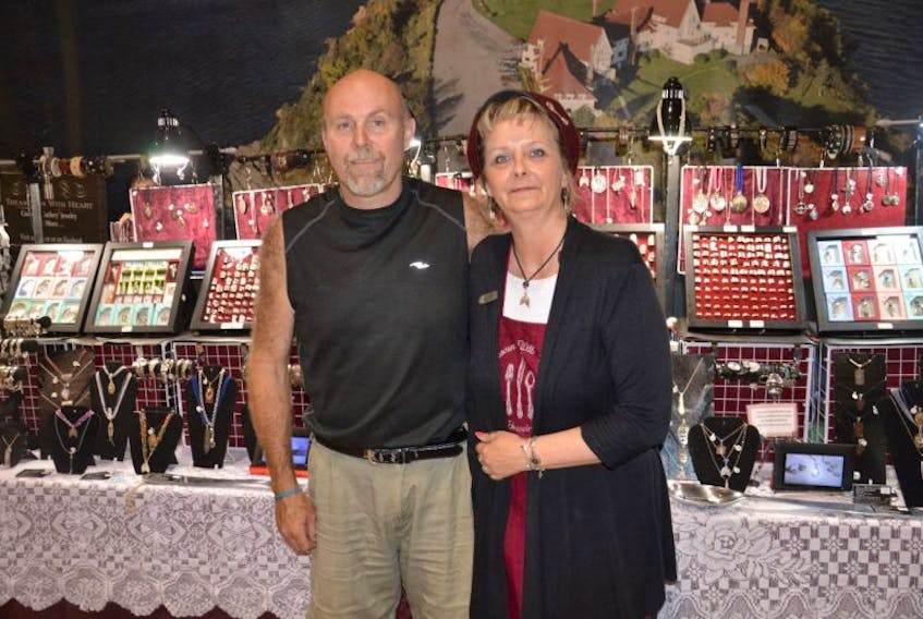 Dwayne and Heather Day, of Treasures With Heart Jewelry, stand in front of their jewelry display at the Joan Harriss Cruise Pavilion on Tuesday. The company makes jewelry from cutlery and family heirlooms and sells them to customers all around the world.