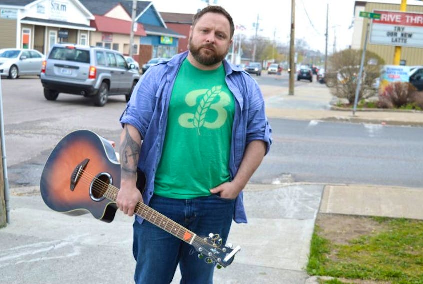 Rob Murphy of New Waterford stands on Plummer Avenue with his guitar. Murphy, a singer/songwriter, was so shocked about the 354-day wait time for mental health assistance in the CBRM he wrote a song ‘300 Days’ a few months ago that is now being promoted by the Canadian Mental Health Association for Mental Health Month in May. Murphy will be opening the Town Hall meeting concerning the lack of resources for mental health and drug addiction at the New Waterford fire station Tuesday, May 23, at 6:30 p.m., with his song.