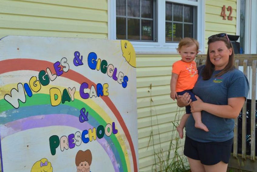 Amber Gillis, assistant director at Wiggles and Giggles Daycare in Sydney, stands outside the facility with her 15-month-old daughter, Logan Wadden.