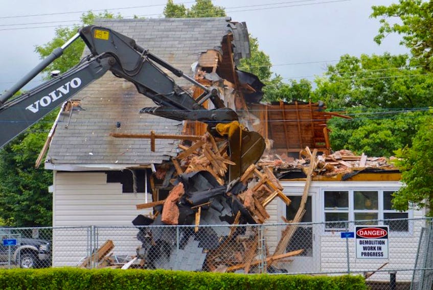 In this file photo from last month, an excavator’s jaws of destruction chomp down on a Royal Avenue house that was deemed uninhabitable following last October’s Thanksgiving Day flood. CBRM councillor Ray Paruch has asked the municipality’s engineering, planning and legal departments to look into options for the south end Sydney neighbourhood that is now a haphazard collection of empty lots, condemned structures and occupied houses.