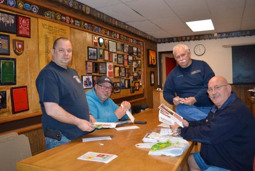 From left, North Sydney volunteer firefighter Pierre Sibley, assistant deputy chief Nelson Scott, Chief Lloyd MacIntosh and Capt. Harry Taylor are seen here with donations received as part of the department’s ongoing coin card campaign.
