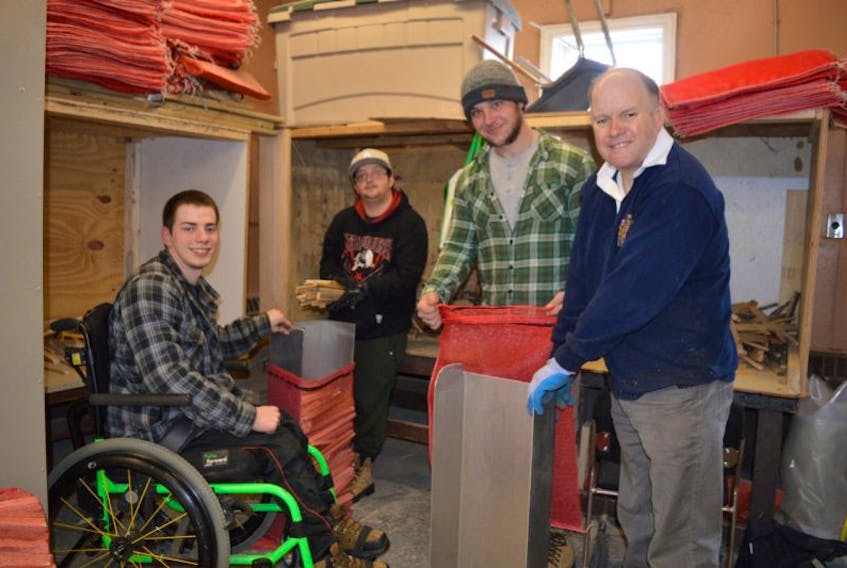 From left, Haley Street Adult Service Centre participants Dylan Tizzard, Camden MacDonald, woodworking instructor Mark MacLeod and participant Peter Eyking fill net bags with kindling.