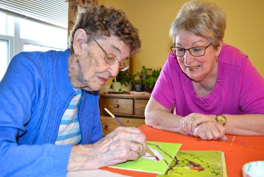 Margaret Reid, left, 94, a resident of Seaview Manor nursing home in Glace Bay and a member of the manor’s art group, chats with the group’s facilitator Cecilia McIntosh while working on artwork for the annual art show on Thursday from 1-4 p.m. Reid said it’s a great feeling when someone purchases your artwork.