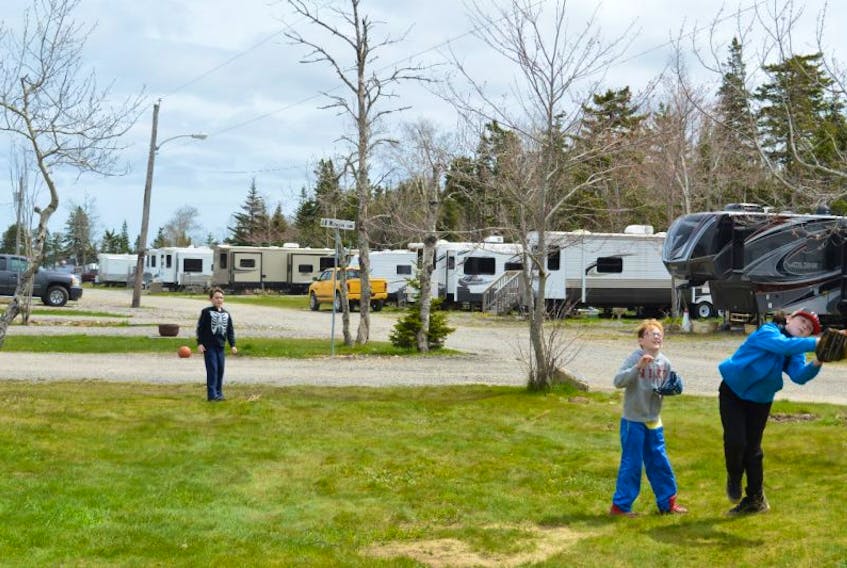 Brady Eagles, 7, throws the ball to his brother Tristen, 11, and friend Drake Deveaux, 10, at the Lakeview Campground in Catalone on Sunday.