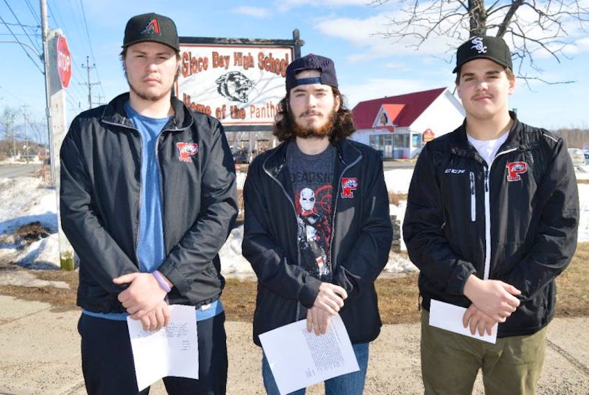 Members of the Glace Bay High School Panthers, from left, Kaine Drake, Logan Bresowar and Connor Campbell stand by the entrance to the high school on Reserve Street, Friday. The hockey players are holding letters they have written to school administration and the Nova Scotia School Athletic Federation, appealing for high school hockey to be reinstated.
