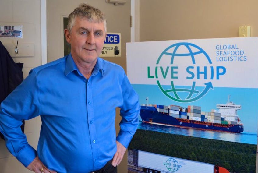 Jim Gillis, president of Live Ship Logistics, stands in front of his company’s promo board on Tuesday. Gillis, who shares company ownership with his brother Allan Gillis, is looking for people to invest in the company.