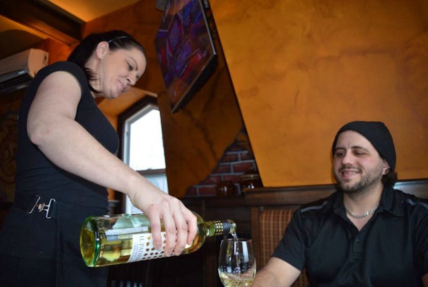 Governors Pub & Eatery server Tara Bearnes pours a glass of wine for customer Joey Boutilier on Tuesday in Sydney. New regulations no longer requiring food to be served with an alcohol order are being lauded by members of Nova Scotia’s restaurant community.