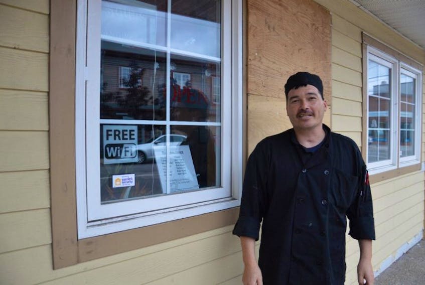 Anthony Fong, co-owner of the Maple Leaf Restaurant on Charlotte Street in Sydney, stands beside a window that is boarded up because a vandal broke it Sunday morning. This is not the only business in the downtown area that’s been hit by random acts of vandalism over the past few months.