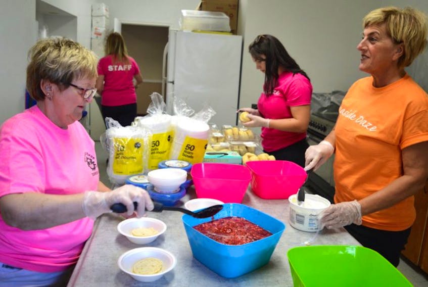Volunteers with Seaside Daze prepare treats for the free seniors strawberry festival at the Dominion fire hall on Monday as part of Seaside Daze festivities. From left are Sheila Peori of the Dominion and area recreation committee, Cassie Gillis of the Seaside Daze committee and Lisa Facchin, also with the recreation committee. The volunteers estimate 200-300 attend the event which includes entertainment by Mario Colosimo. Seaside Daze continues until Sunday.