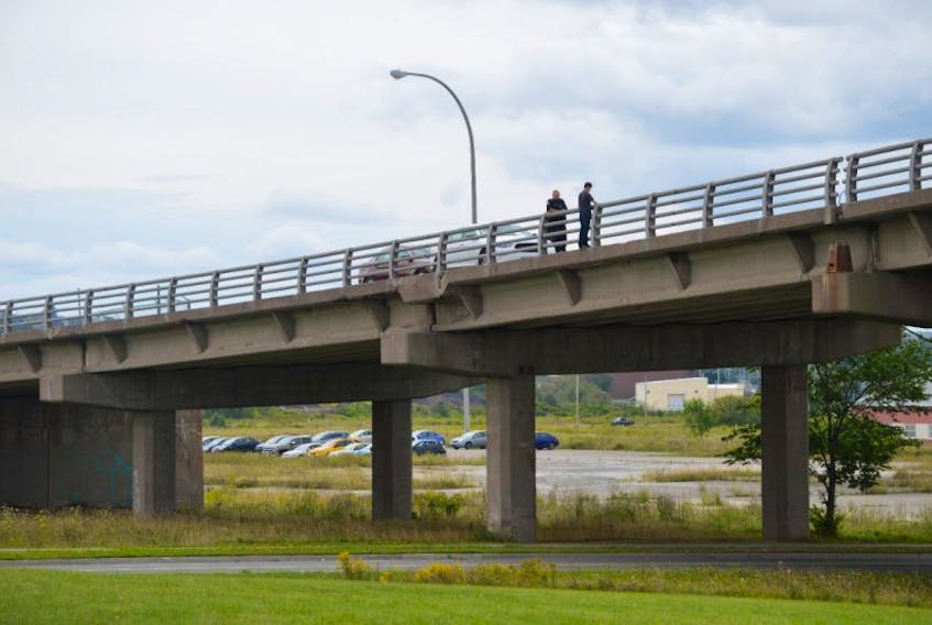 A man, who appeared to be in his 20s, speaks with a Cape Breton Regional Police officer Friday on the Victoria Road overpass, which connects Whitney Pier with Sydney. The overpass and the Sydney Port Access Road, which runs under it, were closed to traffic for about three hours on Friday morning and early afternoon. The road reopened to traffic shortly after 2 p.m.