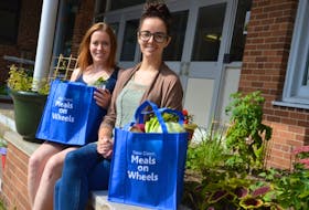 Claire Turpin, front, and Kathleen Whelan show off bags full of fresh produce and meat that will be delivered to seniors on Thursday as part of the age-friendly food box pilot program. The program is being done through meals on wheels and continues until Oct. 26.