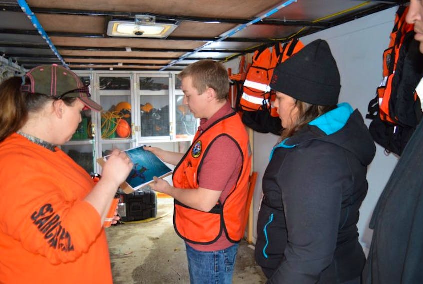 Kyle MacLeod, centre, the search manager for Cape Breton Search and Rescue, goes over search plans with Bridget Barrie, left, and Stephanie Hawley, right, just prior to a search of the Cossitt Heights area of Sydney. 