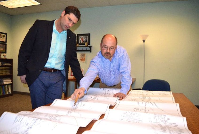 Minister of Transportation Geoff MacLellan, left, and Jim Bunn, senior vice president of operations for Cutlass Collieries and CAO at the Donkin Mine, look over a map of the planned coal road route from the mine along the former railbed behind Glace Bay — south of Dominion Street — exiting behind the Sydney airport. MacLellan said Kameron Collieries could have used provincial roads but instead are making a significant investment to build a coal road to help mitigate some of the traffic congestion.