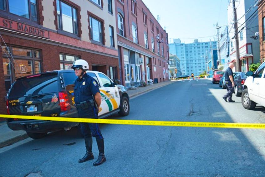 On Tuesday afternoon, a regional police officer watches over a section of Prince Street in Sydney that is now part of a homicide investigation involving a man in his fifties who was found dead in his apartment.
